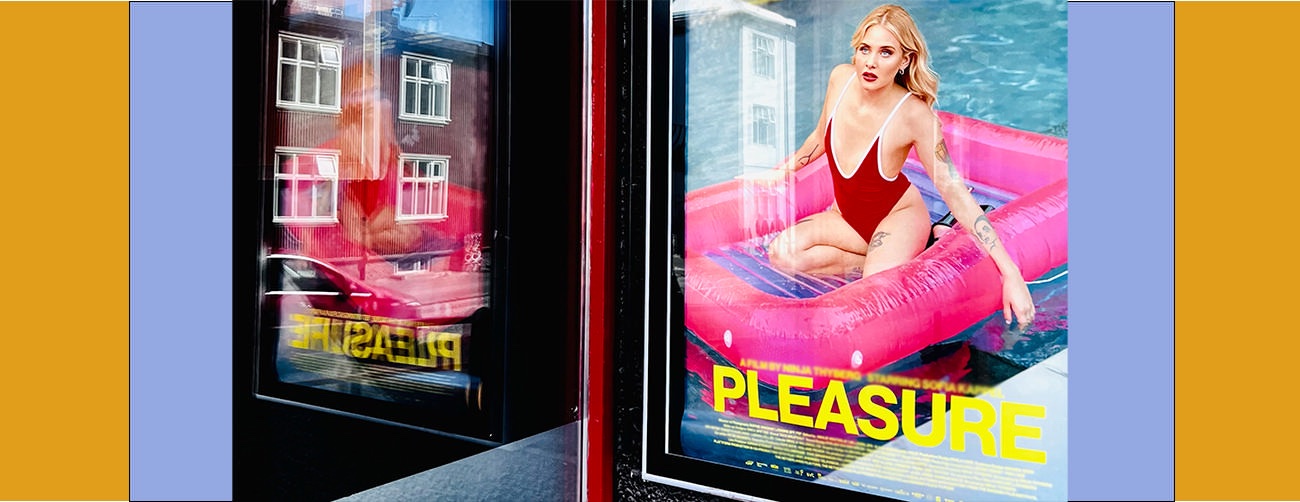 Movie poster of woman in red bathing suit on pink blow-up raft with the title "Pleasure"